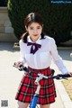 A woman in a school uniform riding a bike.