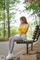 A woman sitting on a bench in a park.