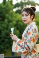 A woman in a kimono holding a fan in her hand.