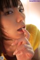 A close up of a woman with her hand on her chin.