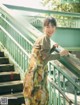 A woman in a long dress standing on a set of stairs.