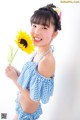 A young girl holding a sunflower in her hand.