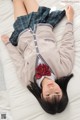 A woman laying on a bed wearing a school uniform.