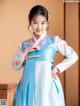 A young girl wearing a blue and white hanbok.