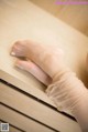 A woman's feet in a white glove on a dresser.